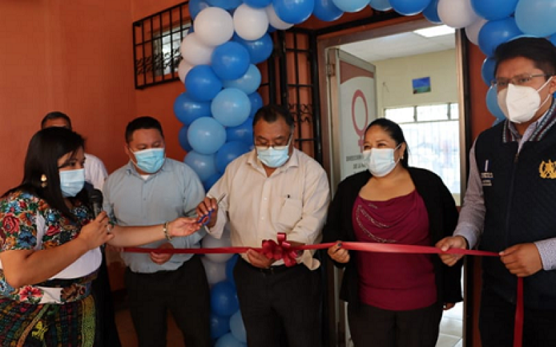 Hombres y mujeres realizan corte de cinta simbólica para inaugurar taller con mujeres emprendedora.