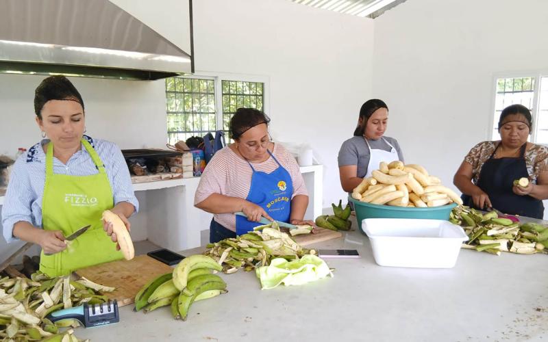 Mujeres de Colpetén preparan harina de plátano para evento de intercambio 