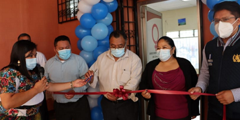 Hombres y mujeres realizan corte de cinta simbólica para inaugurar taller con mujeres emprendedora.